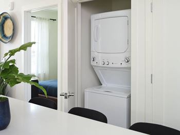 a white washer and dryer in a white laundry room